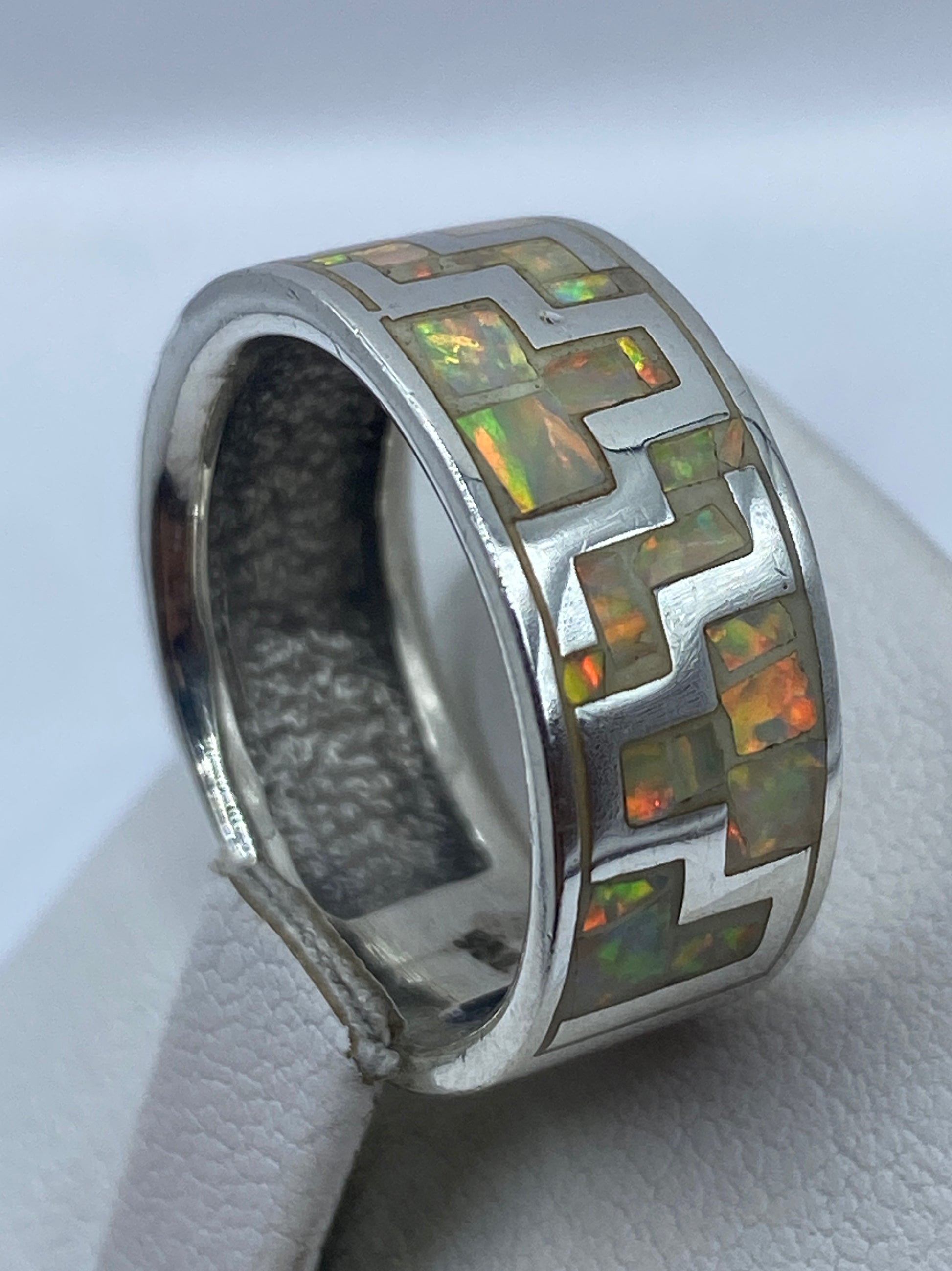Anillo de ópalo de fuego en la mano mostrando brillo y profundidad de color del mineral natural