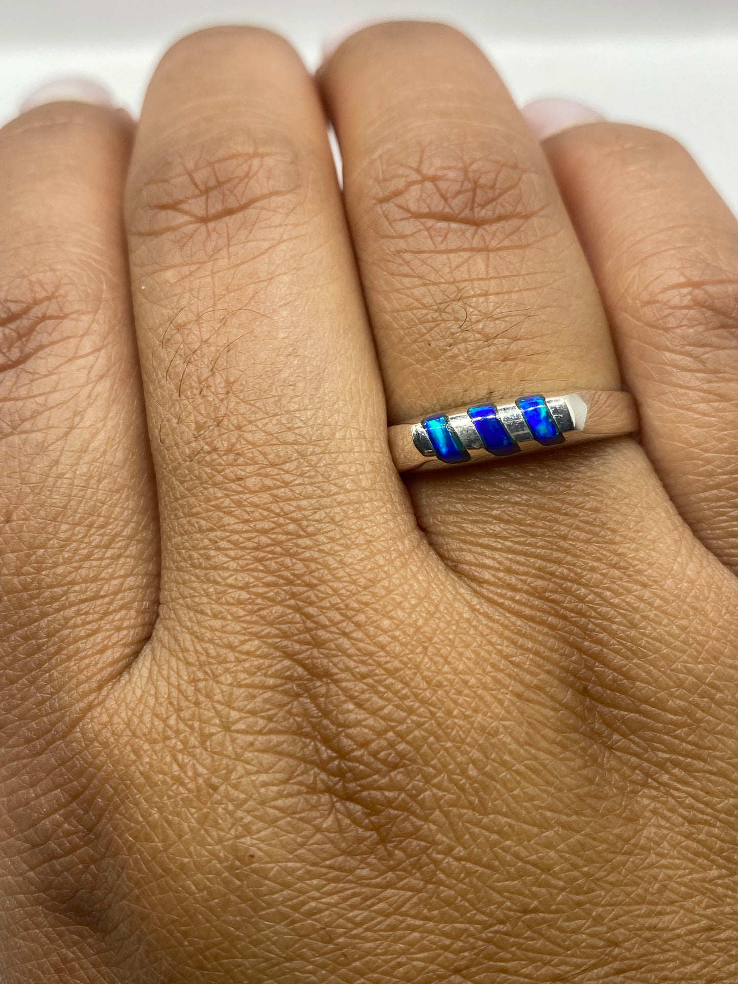 Anillo de ópalo de fuego en dedo, mostrando el sello .925 y la gema natural