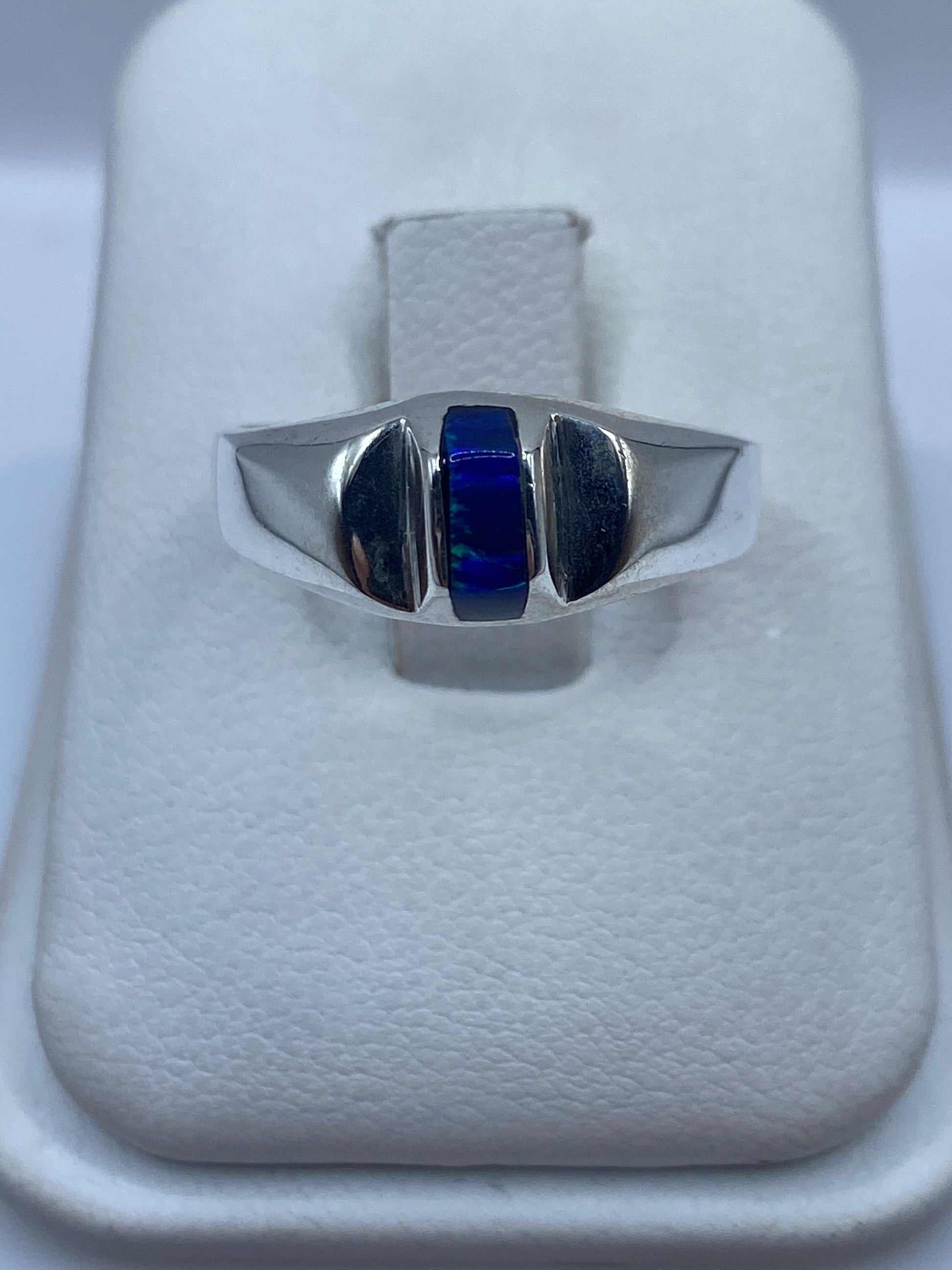 Anillo de plata .950 con ópalo de fuego azul en estuche blanco mostrando el brillo de la piedra