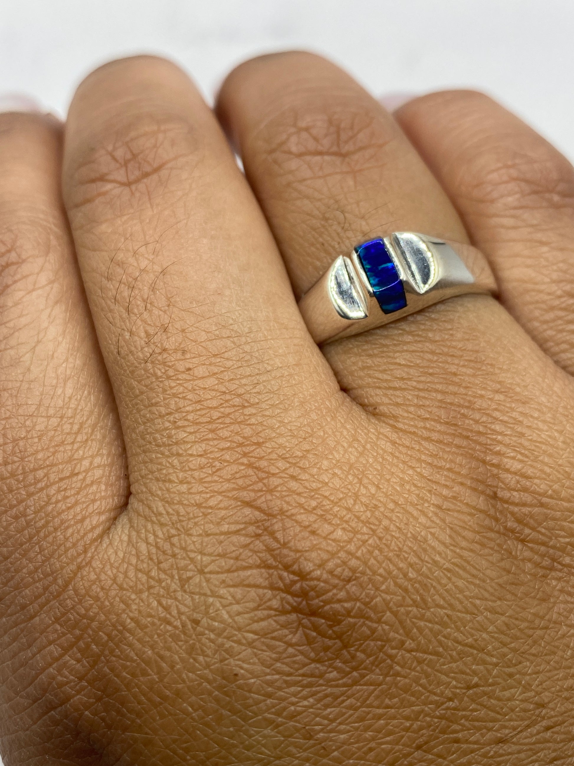 Anillo en mano de mujer exhibiendo el brillo vivo del ópalo con sello .950