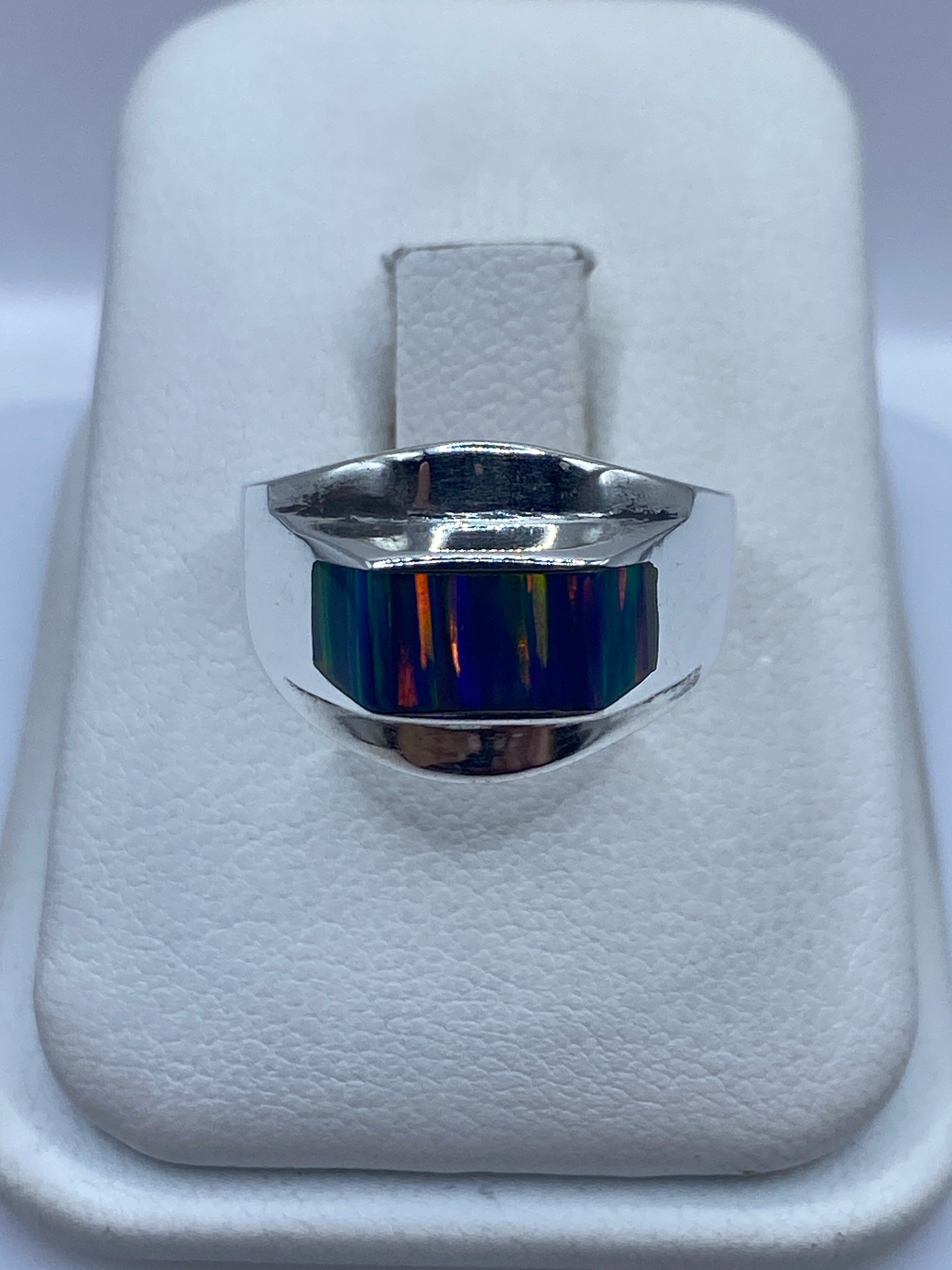 Anillo de plata .950 con ópalo de fuego multicolor sobre almohada blanca, vista frontal