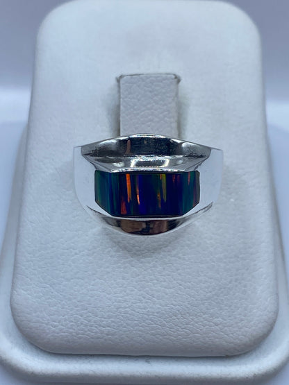 Anillo de plata .950 con ópalo de fuego multicolor sobre almohada blanca, vista frontal