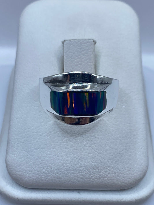 Anillo de plata .950 con ópalo de fuego multicolor sobre almohada blanca, vista frontal