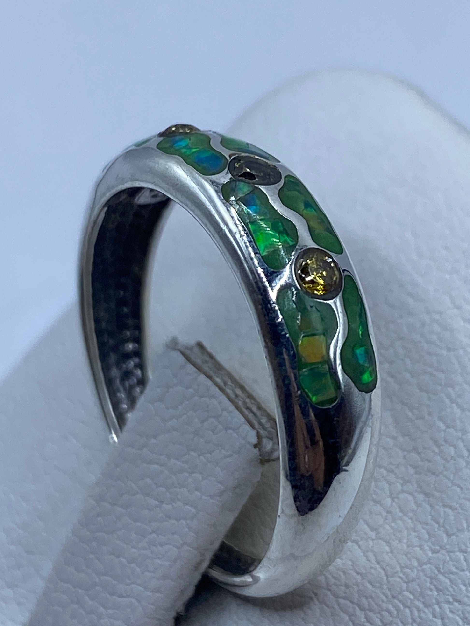 Anillo en la mano mostrando el brillo y juego de fuego del ópalo verde limón