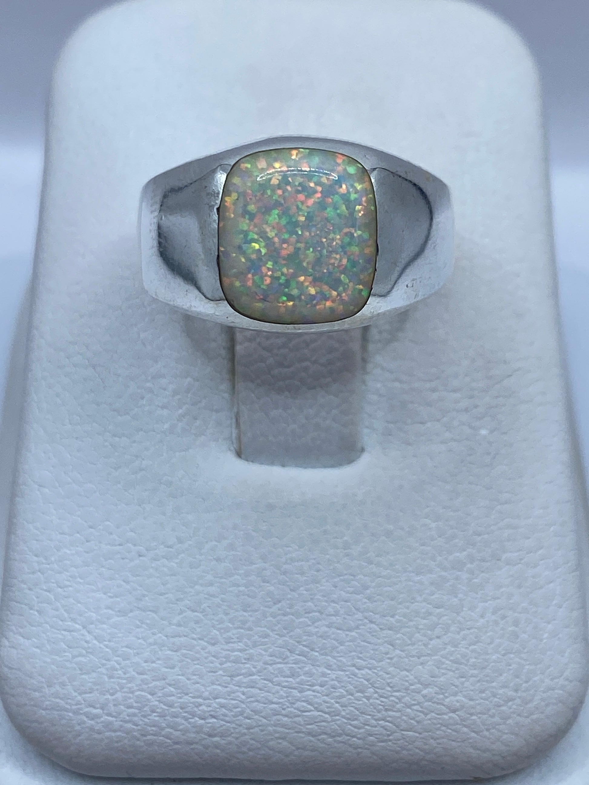 Anillo de plata .950 con ópalo de fuego natural multicolor en la mano de una mujer