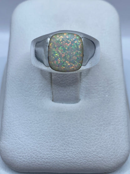 Anillo de plata .950 con ópalo de fuego natural multicolor en la mano de una mujer