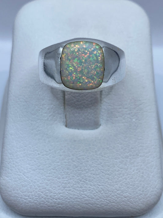 Anillo de plata .950 con ópalo de fuego natural multicolor en la mano de una mujer