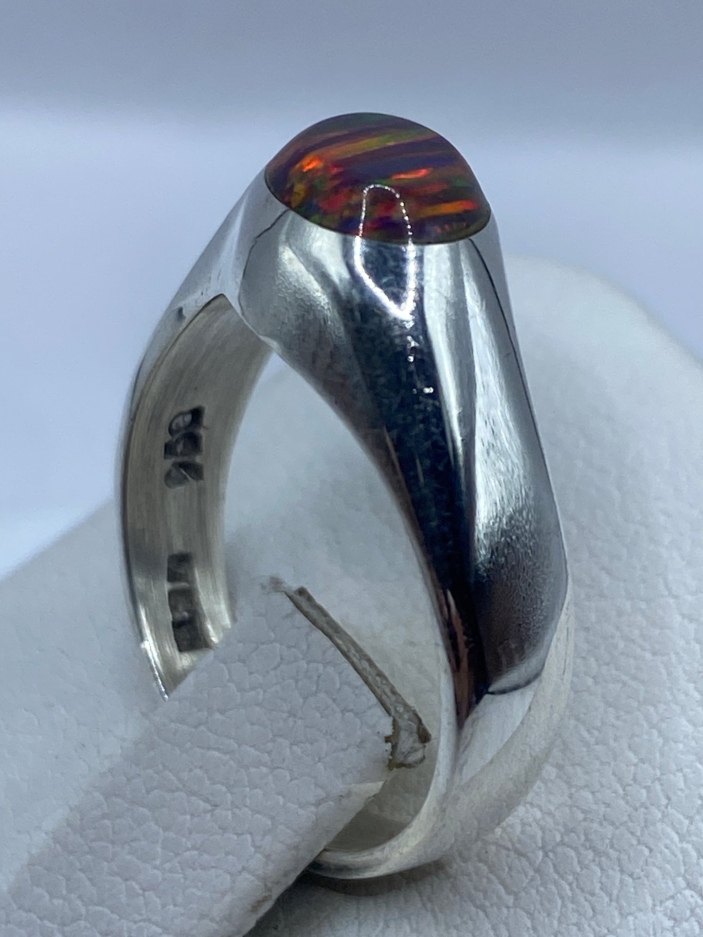 Detalle lateral del anillo en plata brillante con engaste seguro del ópalo
