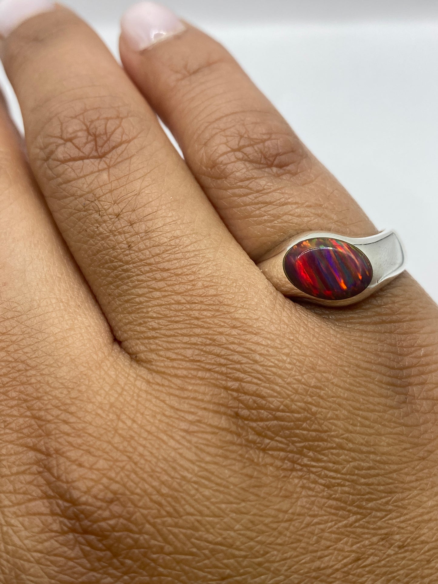 Anillo en dedo mostrando el fuego natural del ópalo bajo luz natural
