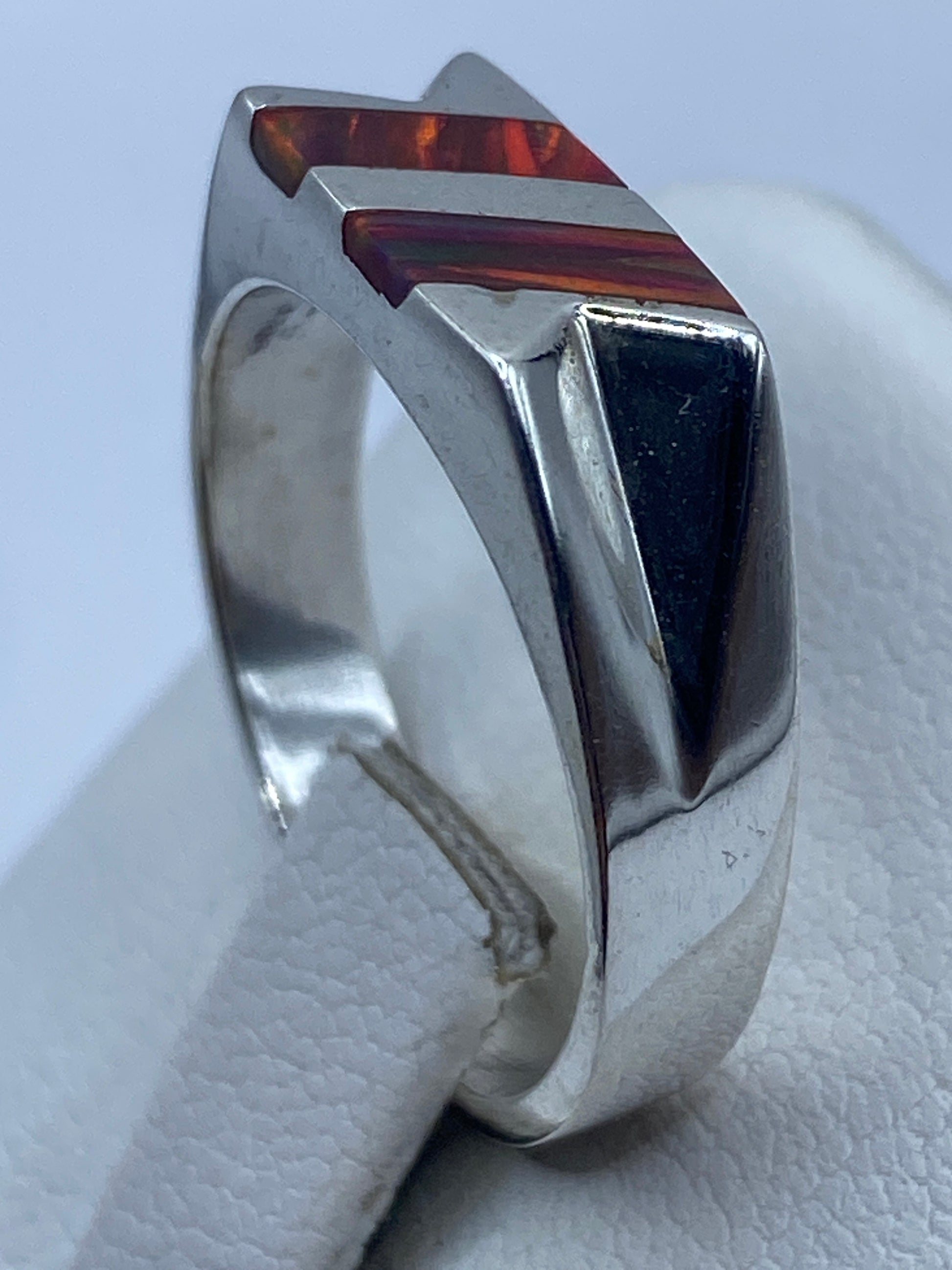 Detalle lateral del anillo mostrando el engaste a mano y el brillo del ópalo