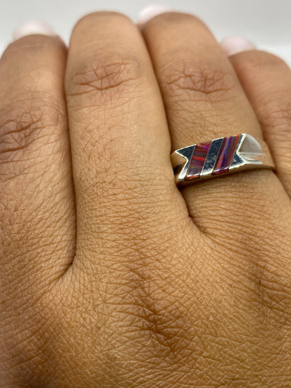 Anillo en la mano mostrando el sello 925 MEXICO y el juego de colores del ópalo