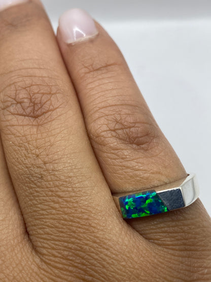 Anillo en dedo mostrando el color azul vibrante del ópalo de fuego natural
