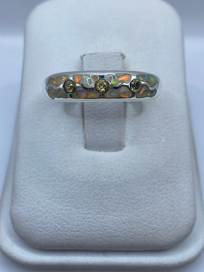 Anillo de plata .950 con ópalo de fuego naranja y verde visto de frente en estuche blanco