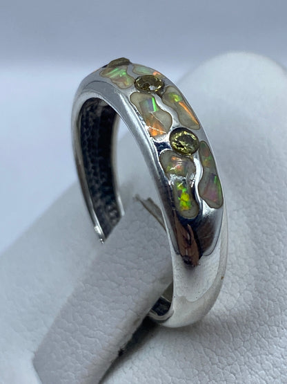 Anillo de ópalo de fuego puesto en dedo, con fuego natural naranja y verde visible