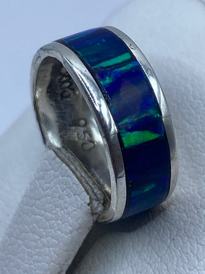 Anillo ópalo azul puesto en dedo mostrando el juego de color