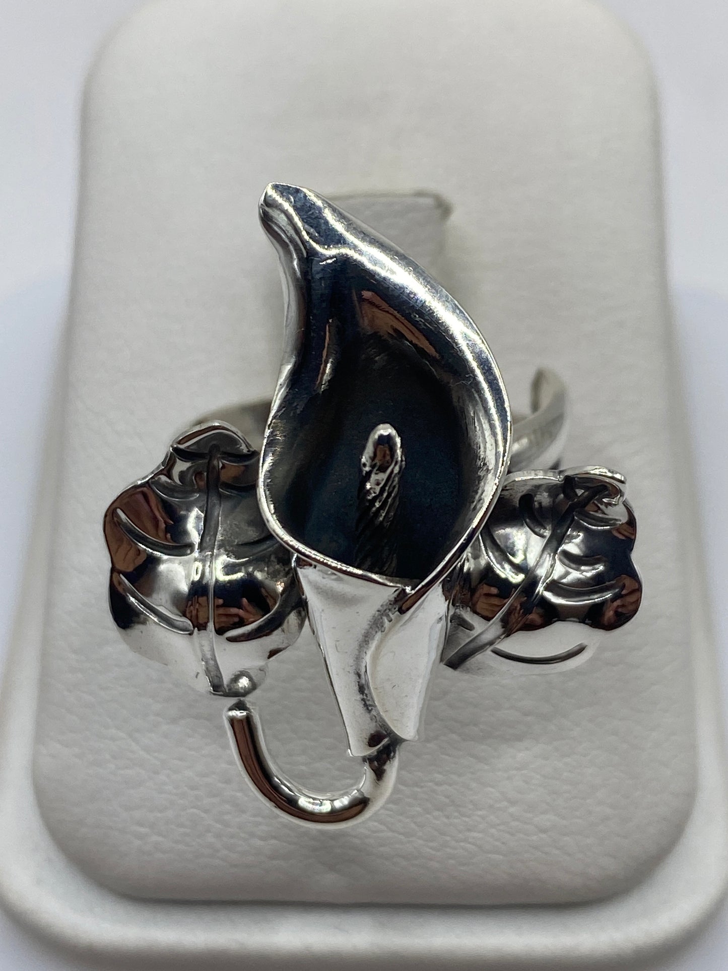 Anillo de plata floral escultural con acabado espejo y oxidado, talla ajustable en mano de mujer
