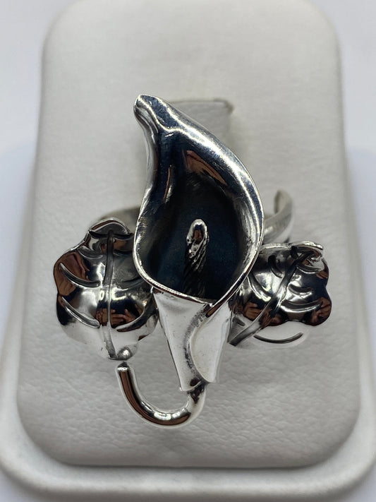 Anillo de plata floral escultural con acabado espejo y oxidado, talla ajustable en mano de mujer