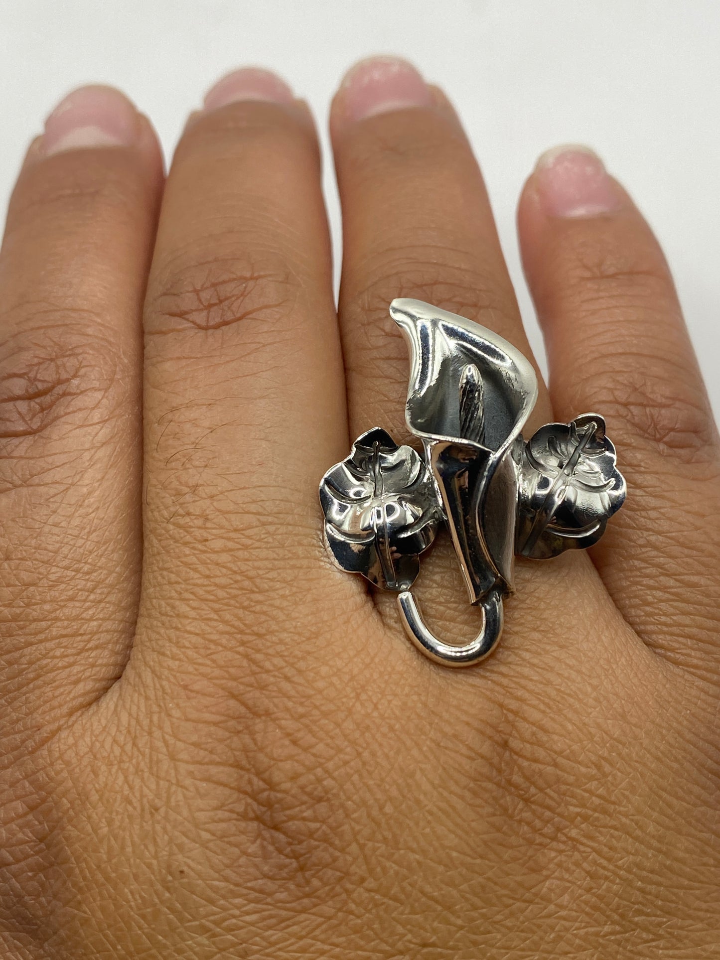 Anillo de flores en plata sobre fondo blanco mostrando el sello .925 de Taxco