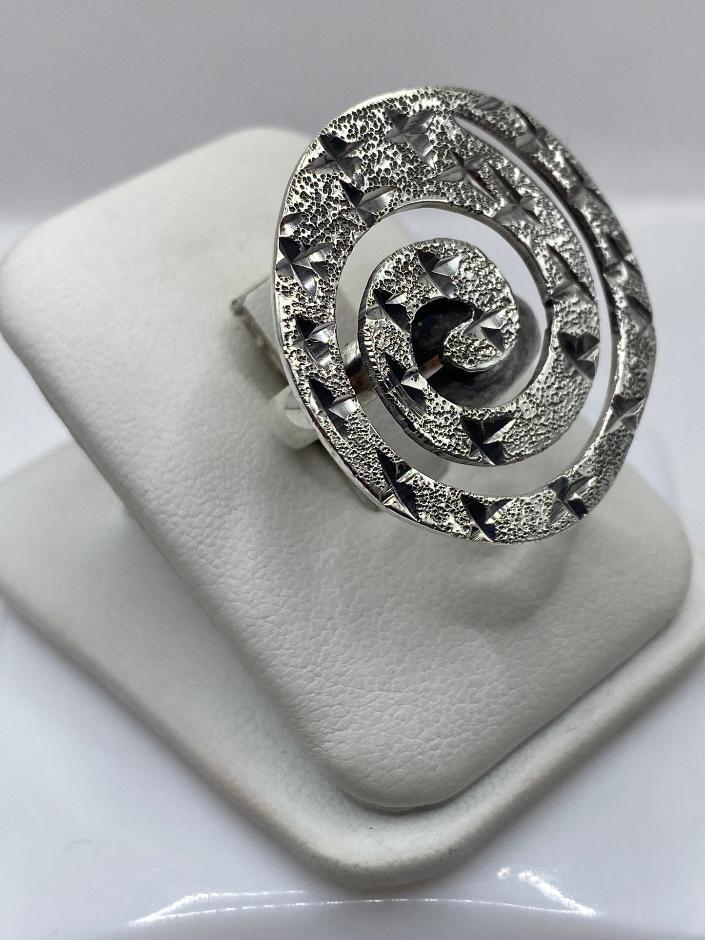 Detalle lateral del anillo espiral mostrando la profundidad de capas giratorias en plata de Taxco