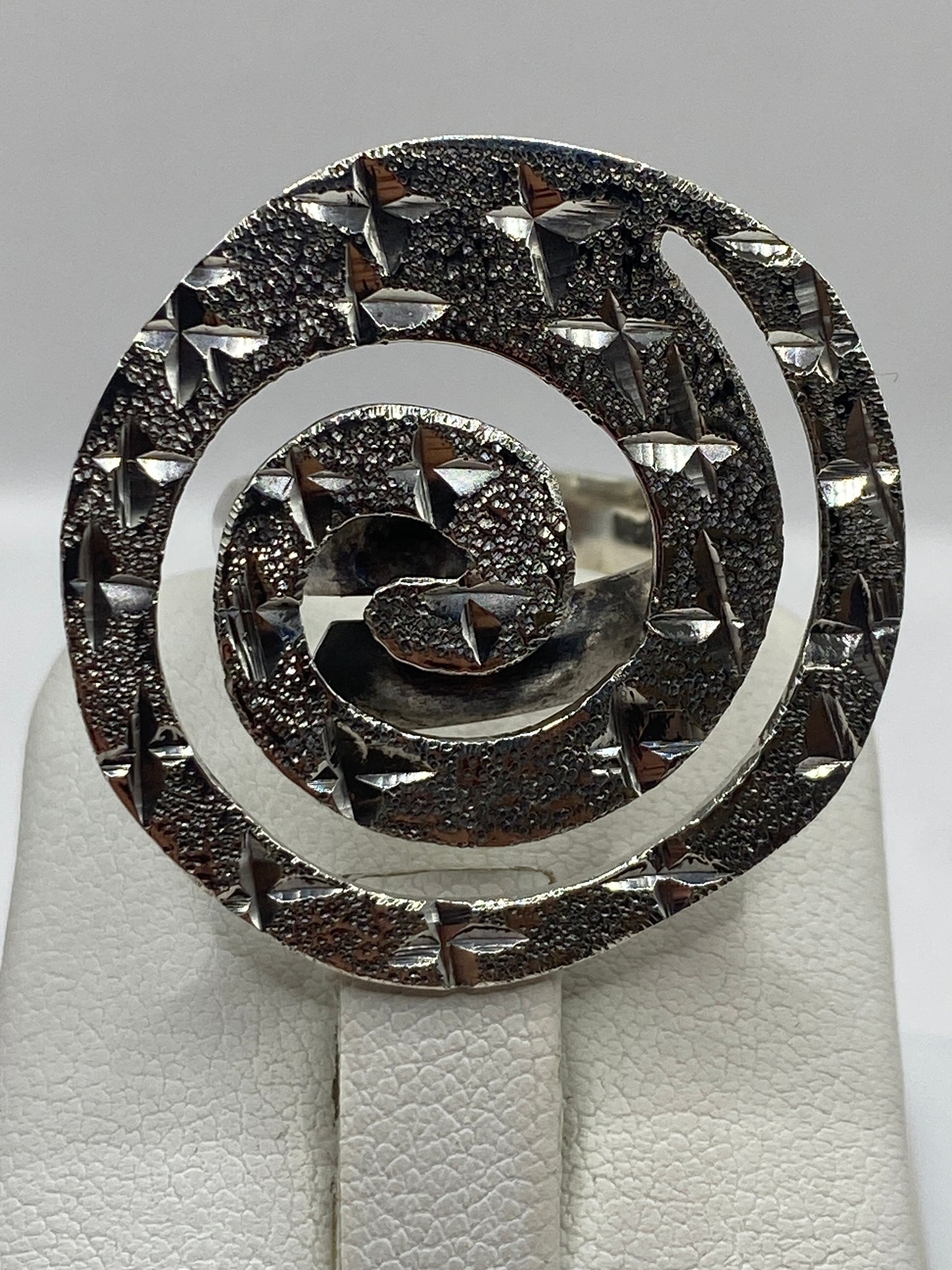 Anillo espiral ajustable en la mano de una mujer, demostrando el movimiento giratorio terapéutico