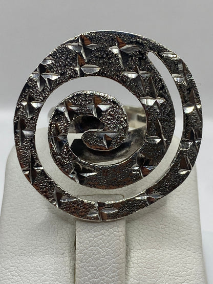 Anillo espiral ajustable en la mano de una mujer, demostrando el movimiento giratorio terapéutico