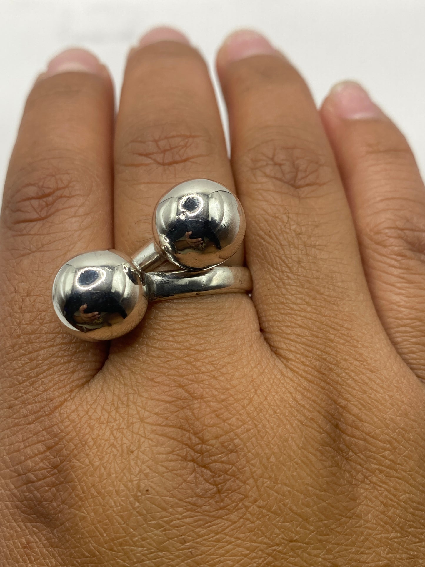 Anillo de dos esferas de plata puesto en dedo, mostrando ajuste perfecto