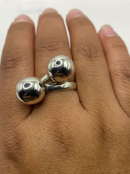 Anillo de dos esferas de plata puesto en dedo, mostrando ajuste perfecto