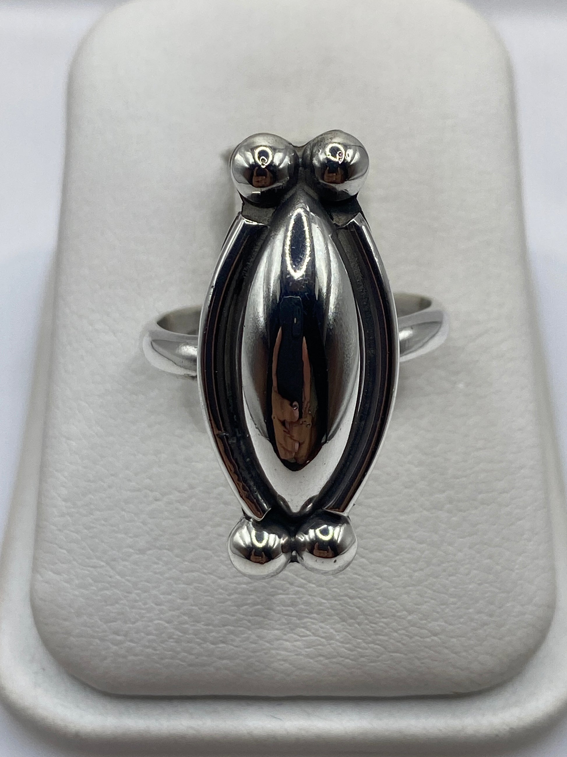 Anillo de plata escultórico con esferas volumétricas pulidas en la mano de una mujer