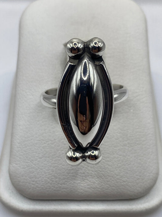 Anillo de plata escultórico con esferas volumétricas pulidas en la mano de una mujer