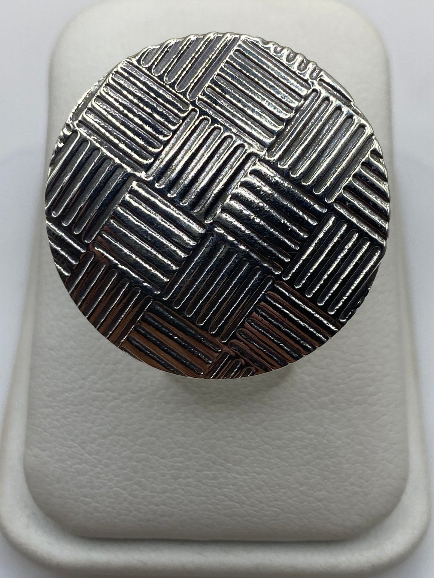 Anillo de plata tejido geométrico ajustable visto desde arriba en estuche blanco