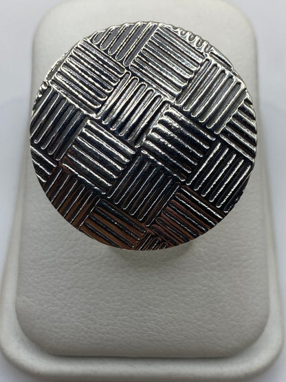 Anillo de plata tejido geométrico ajustable visto desde arriba en estuche blanco