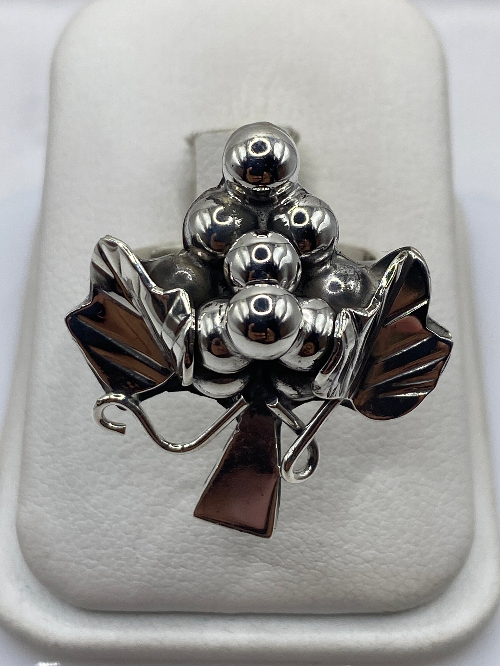 Anillo floral de plata con esferas volumétricas visto desde arriba en estuche blanco