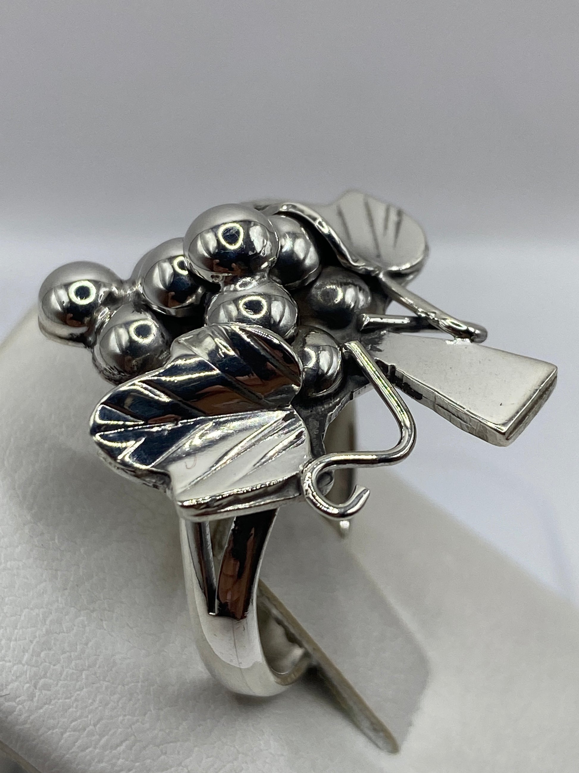 Detalle lateral del anillo floral en plata .925, visto de perfil sobre mano de mujer