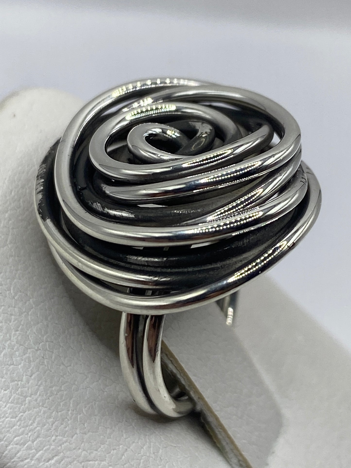 Detalle del anillo giratorio en la mano, mostrando el flujo suave de las bandas