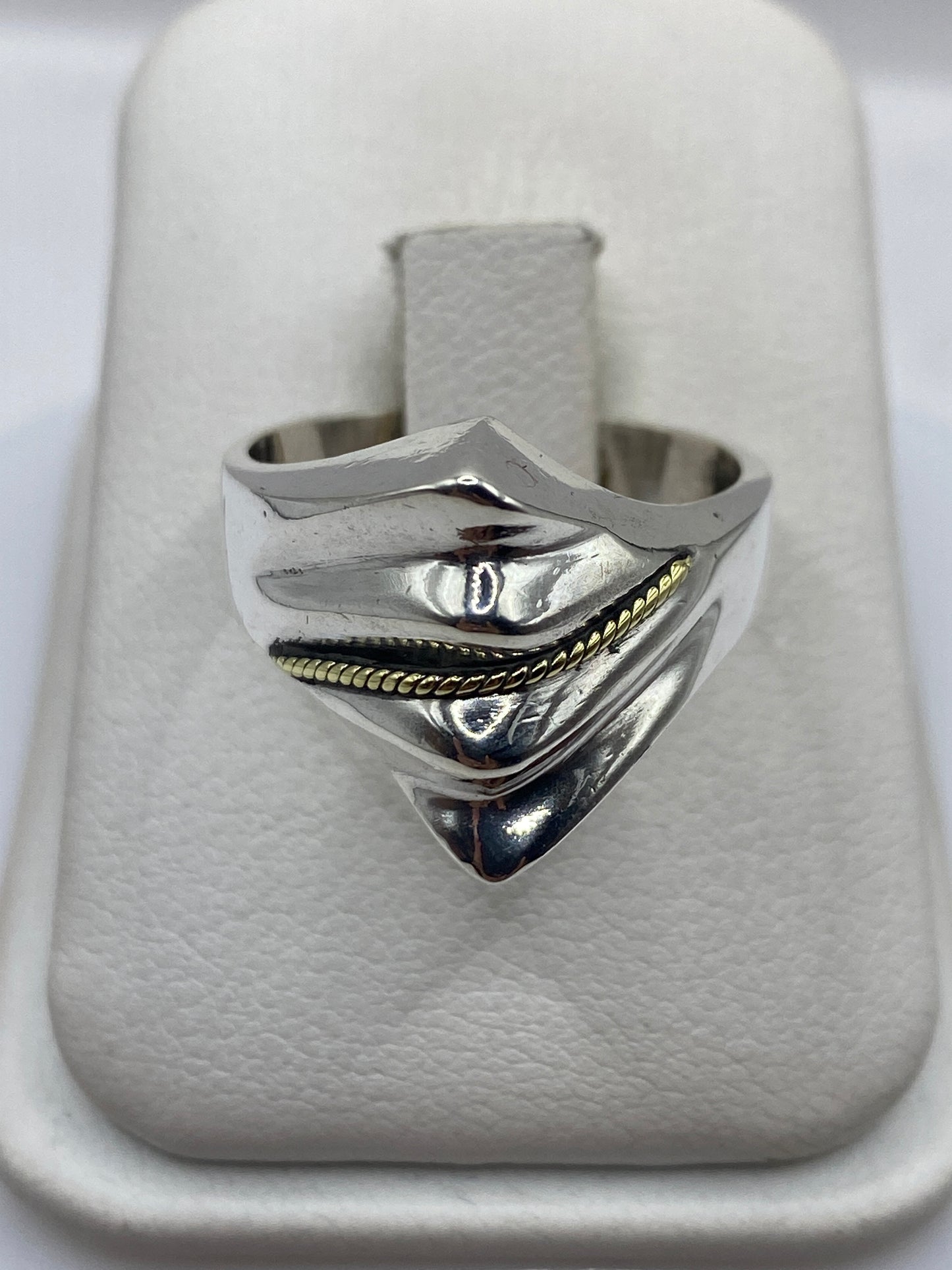 Anillo de plata con bandas superpuestas vistas de frente, mostrando geometría arquitectónica