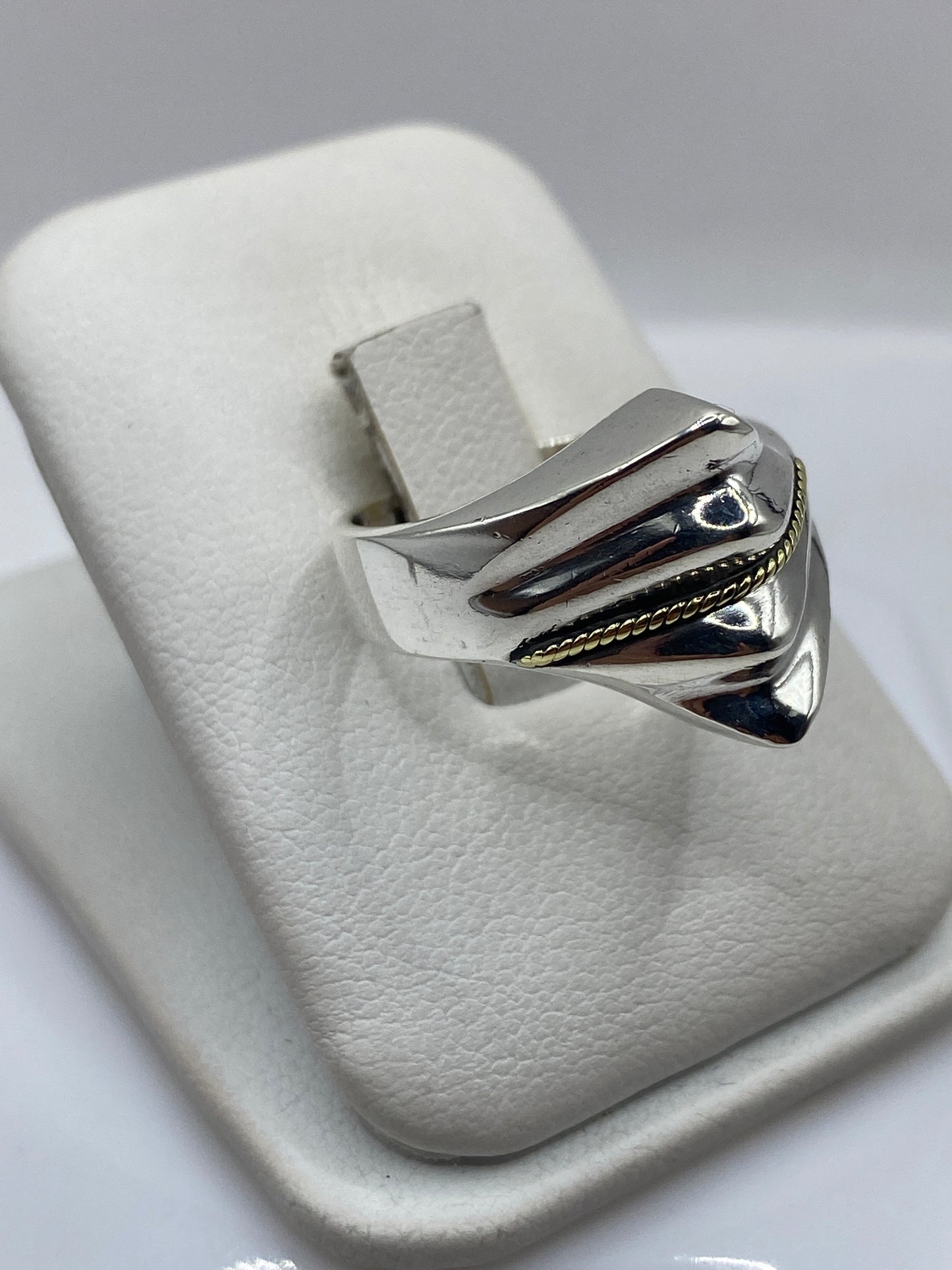 Anillo de plata .925 en la mano, demostrando el peso y presencia real del metal
