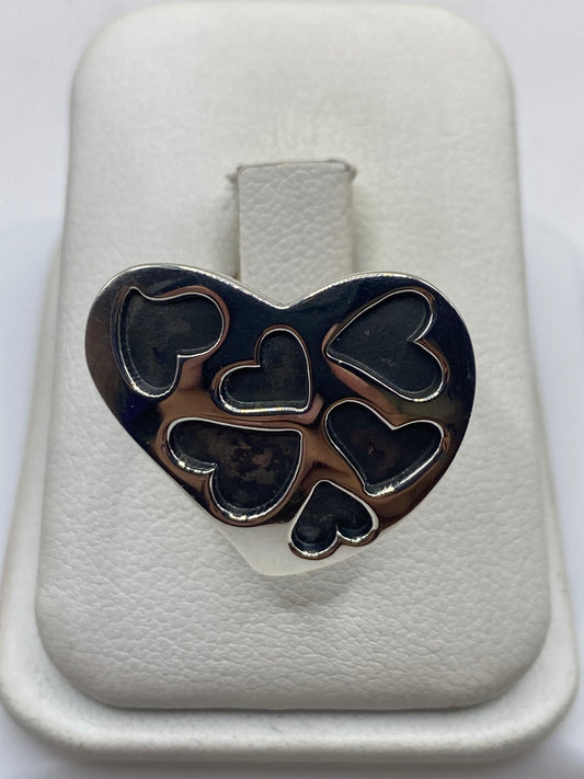 Anillo de plata con cinco corazones abiertos tallados a mano, frente oxidado y banda brillante