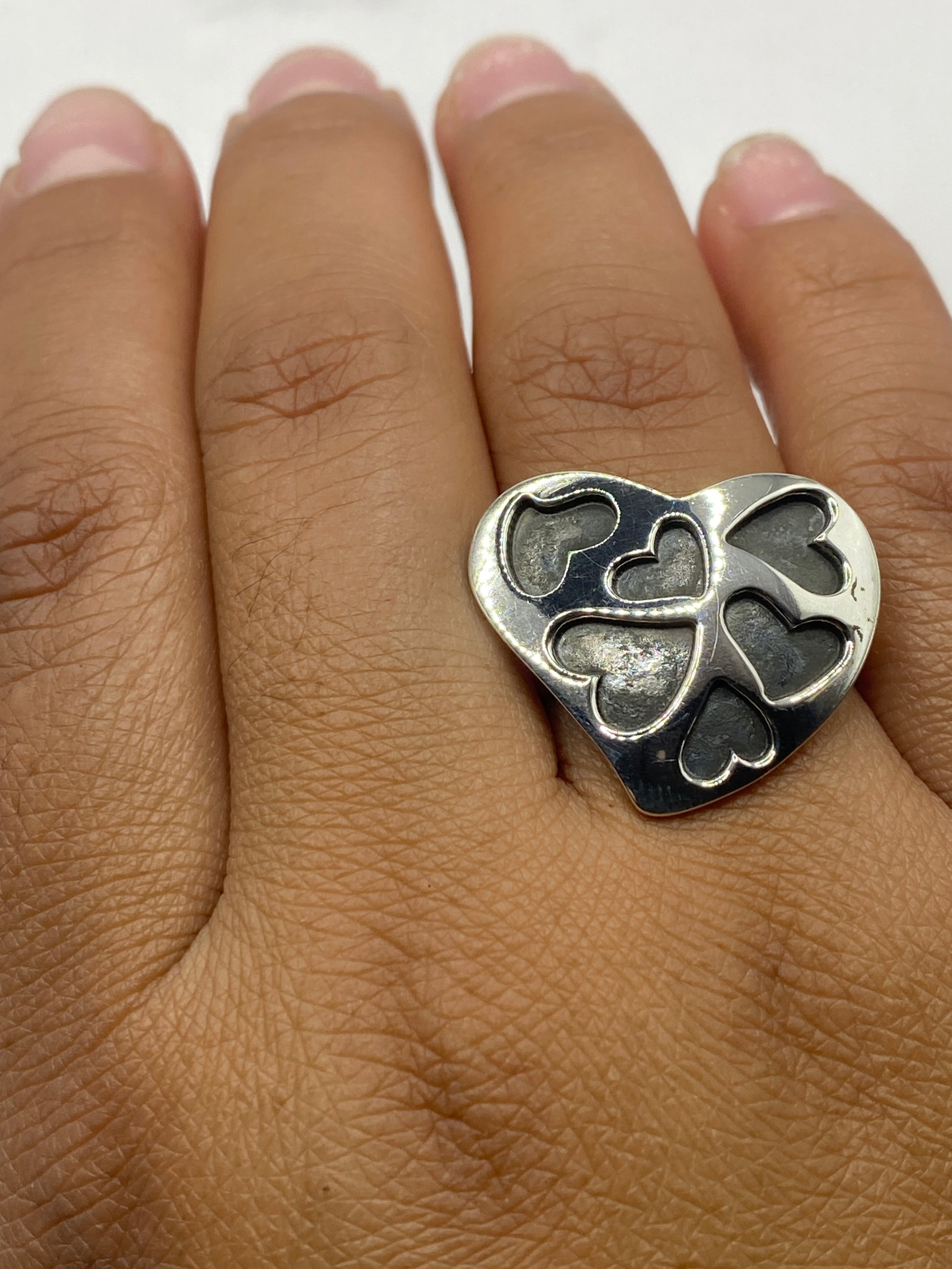 Anillo de plata corazones abiertos sobre piel, demostrando la presencia del diseño en uso diario