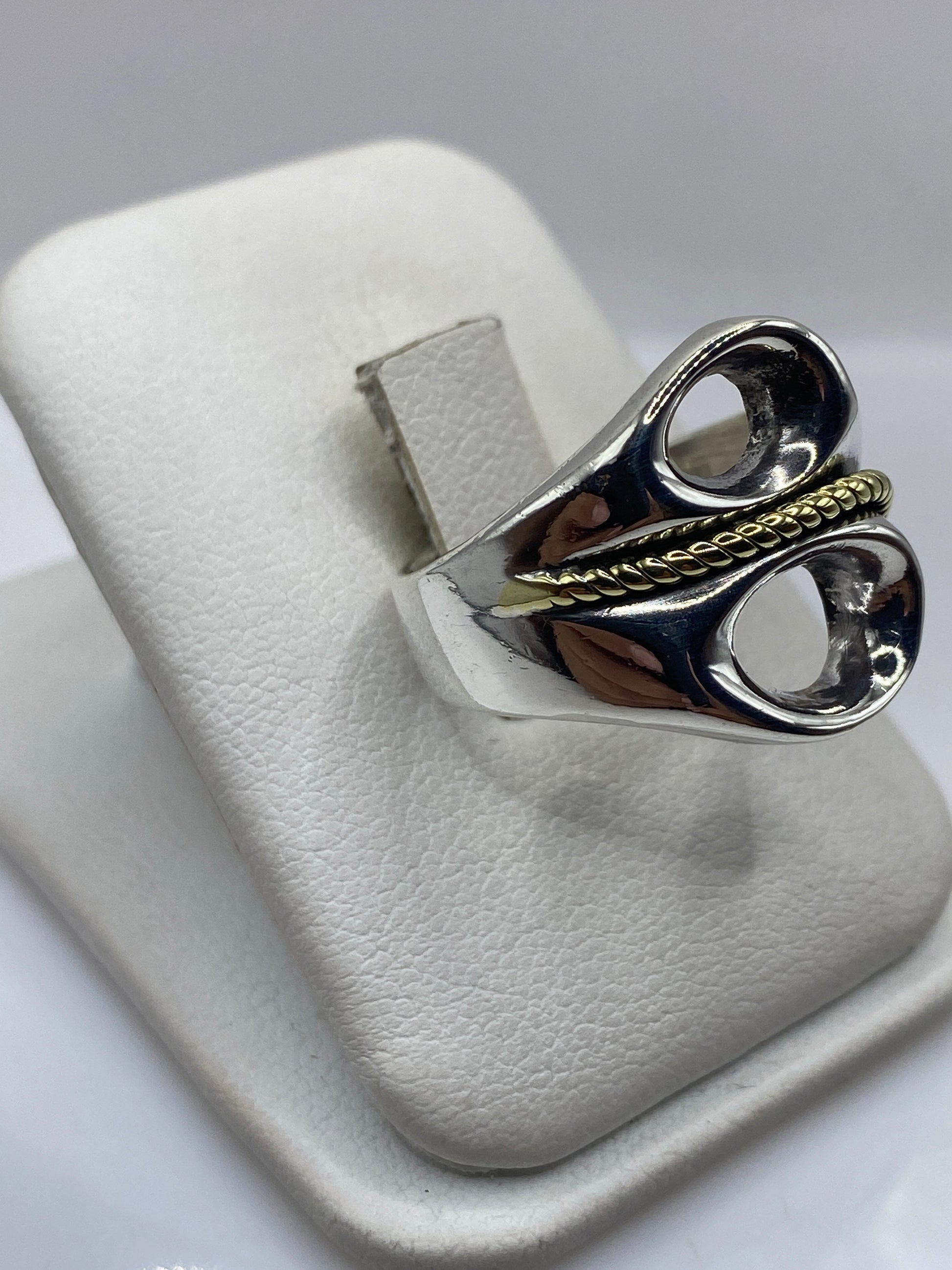 Detalle lateral del anillo mostrando el pulido espejo y la cuerda en oro de 24K