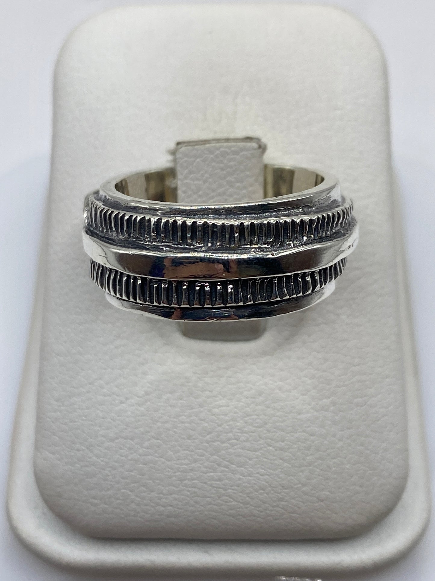 Anillo de plata .925 con bandas texturadas en mano de hombre adulto