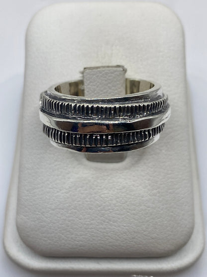 Anillo de plata .925 con bandas texturadas en mano de hombre adulto