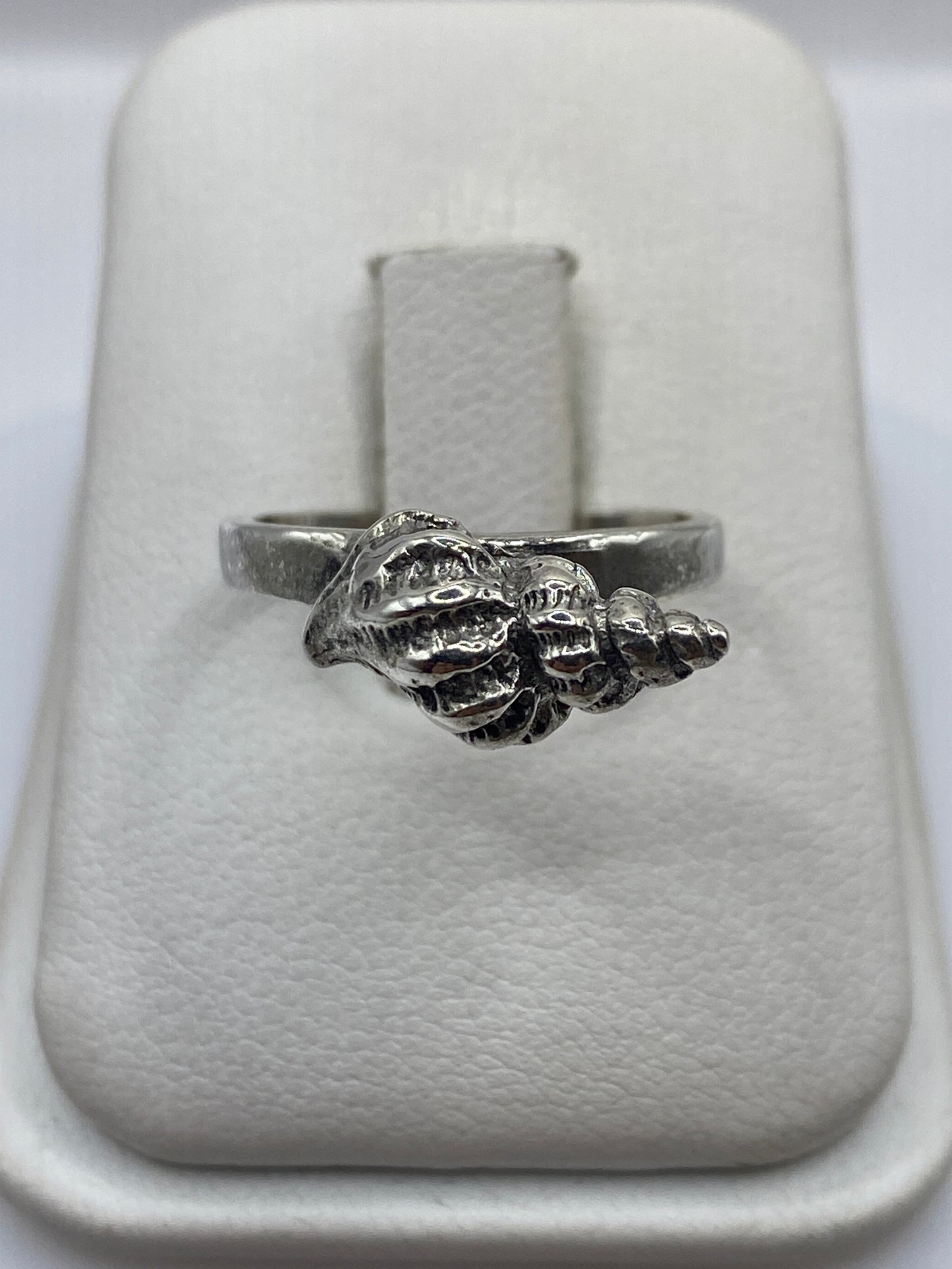Anillo de plata con forma de concha marina, frente detallado con texturas