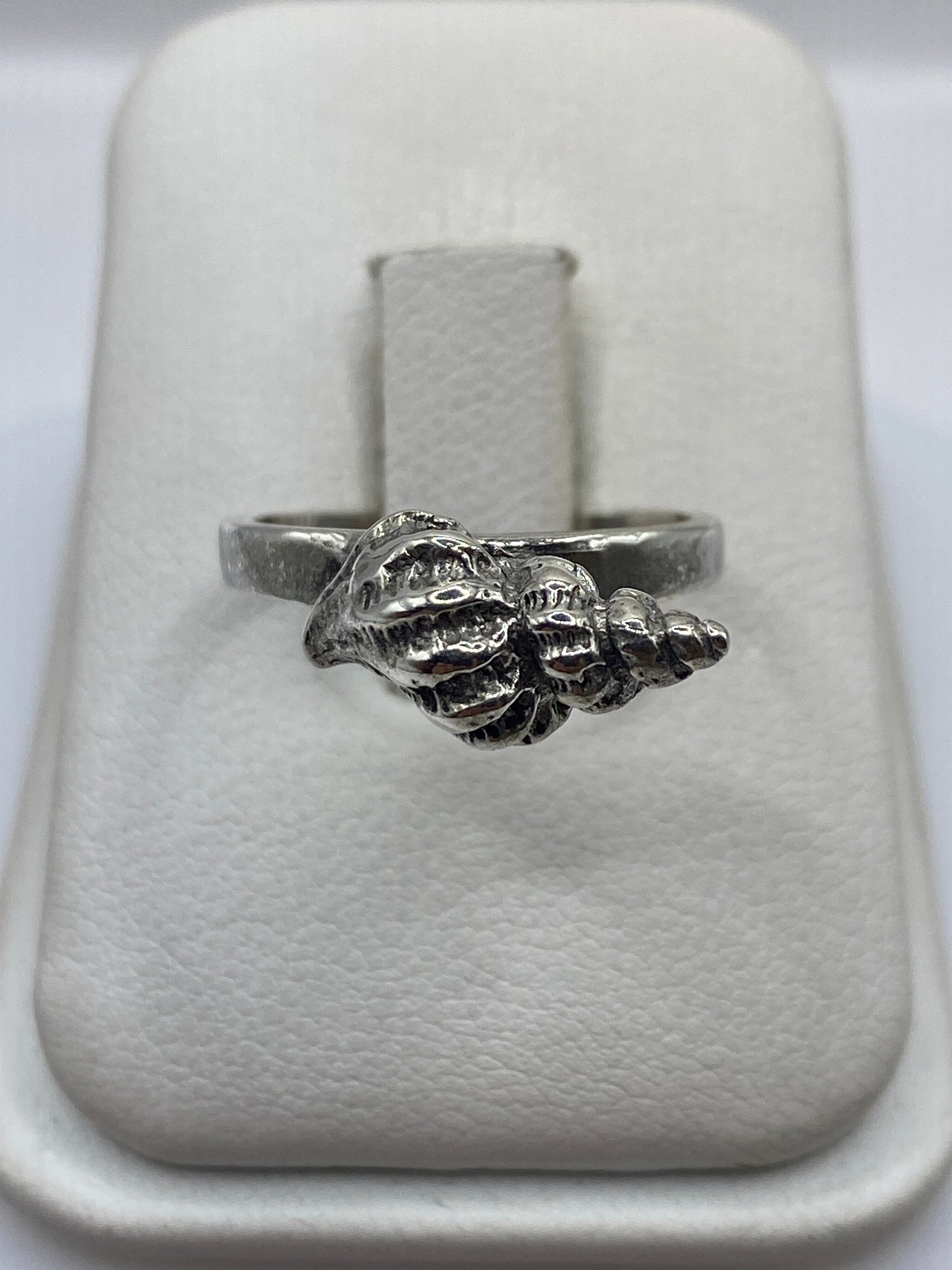 Anillo de plata con forma de concha marina, frente detallado con texturas
