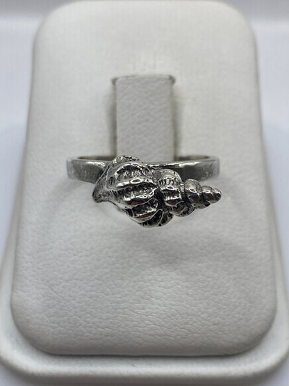 Anillo de plata con forma de concha marina, frente detallado con texturas