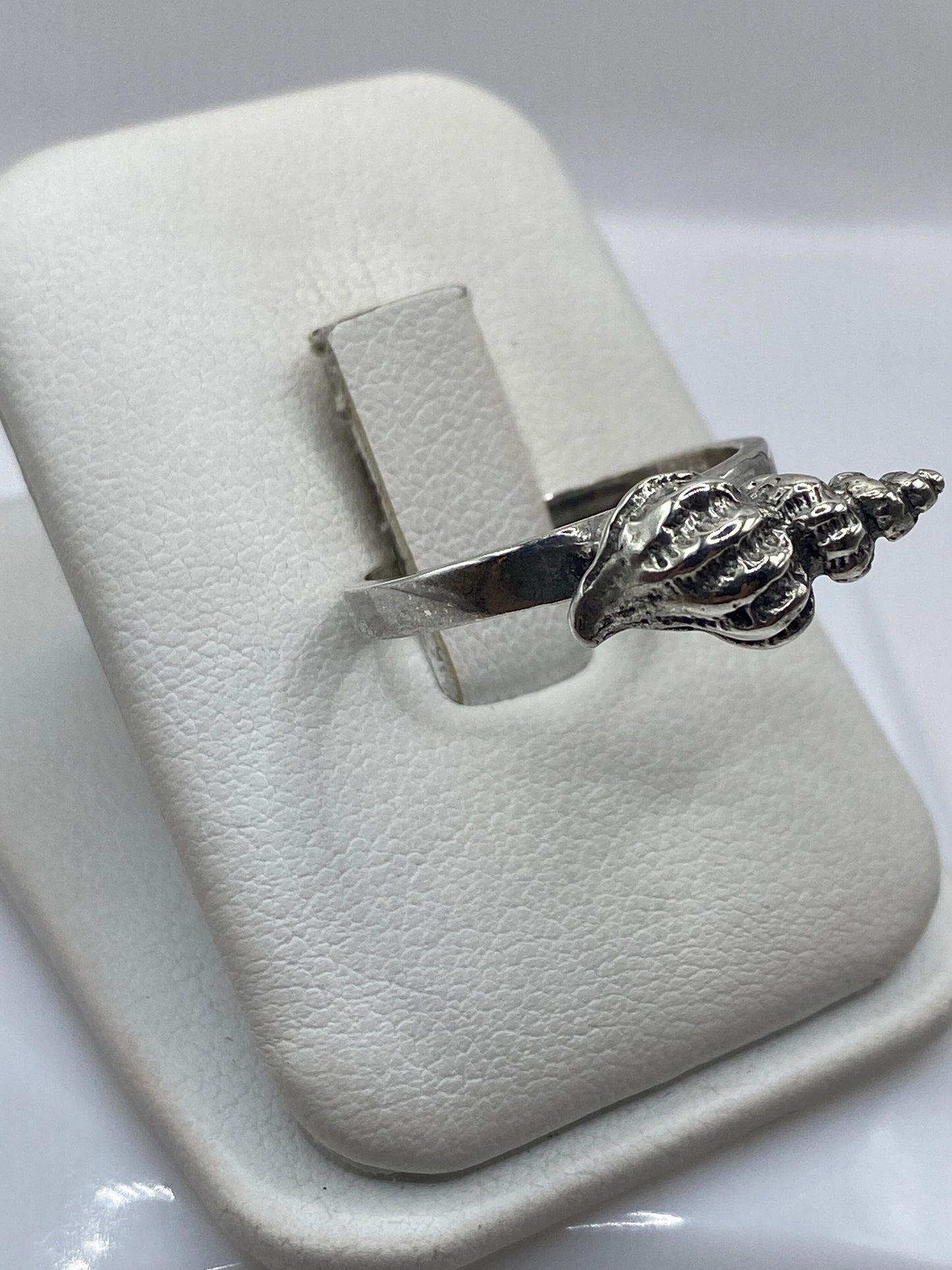 Anillo concha de plata .925 visto de perfil en la mano de una mujer
