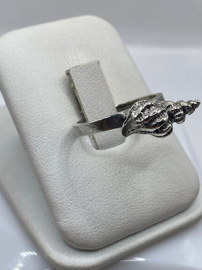 Anillo concha de plata .925 visto de perfil en la mano de una mujer