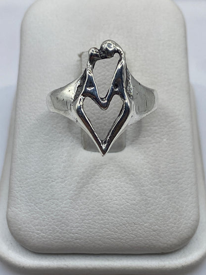 Anillo de plata con manos entrelazadas, diseño escultural brillante sobre fondo blanco