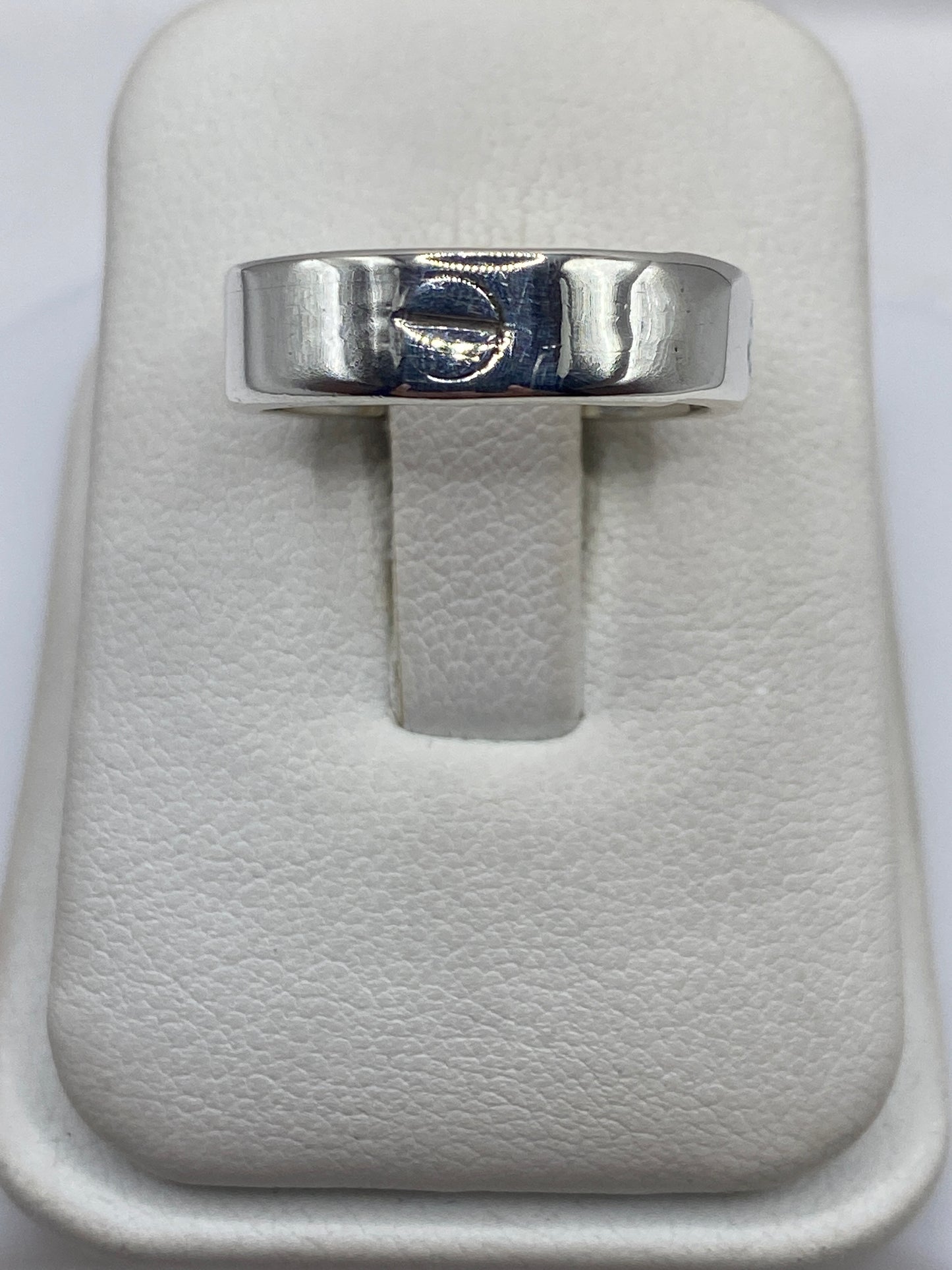 Anillo de plata banda pulida minimalista en estuche blanco, vista frontal