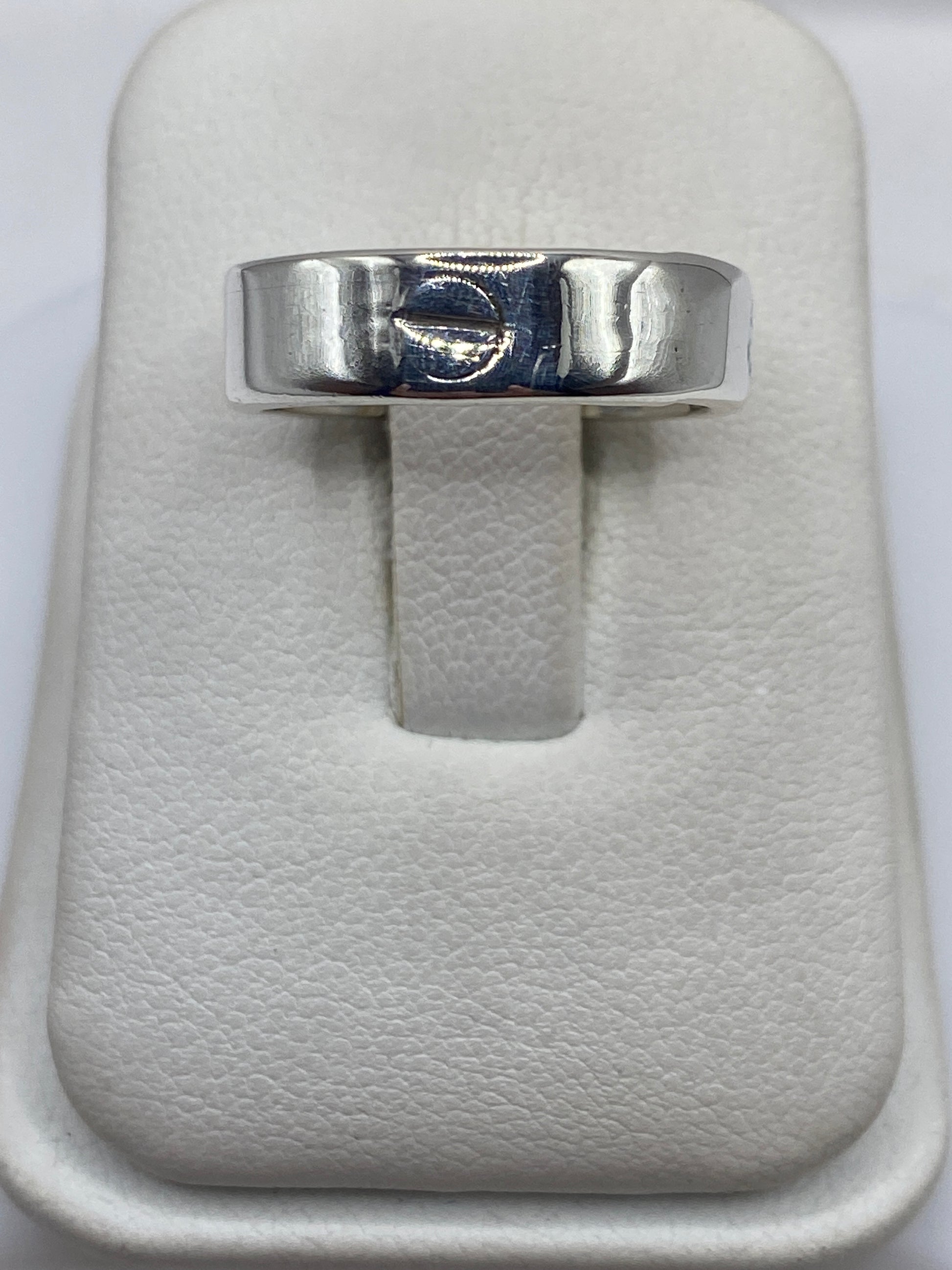 Anillo de plata banda pulida minimalista en estuche blanco, vista frontal