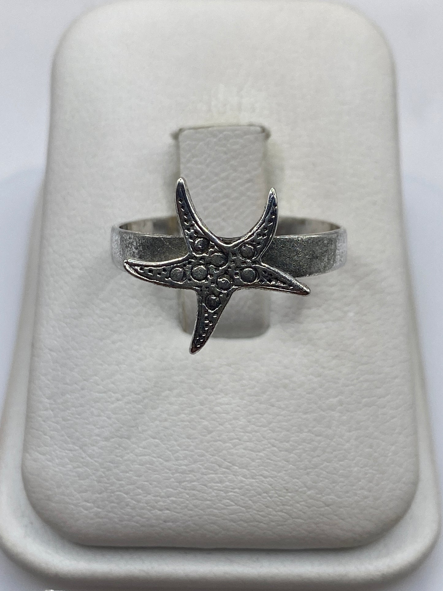 Anillo de plata con diseño de estrella de mar grabada en relieve, vista superior